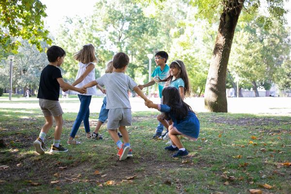 campings/francia/aquitania/landas/Airial/happy-children-playing-together-outdoors-dancing-around-on-grass-enjoying-outdoor-activities-and-having-fun-in-park-kids-party-or-friendship-concept.jpg